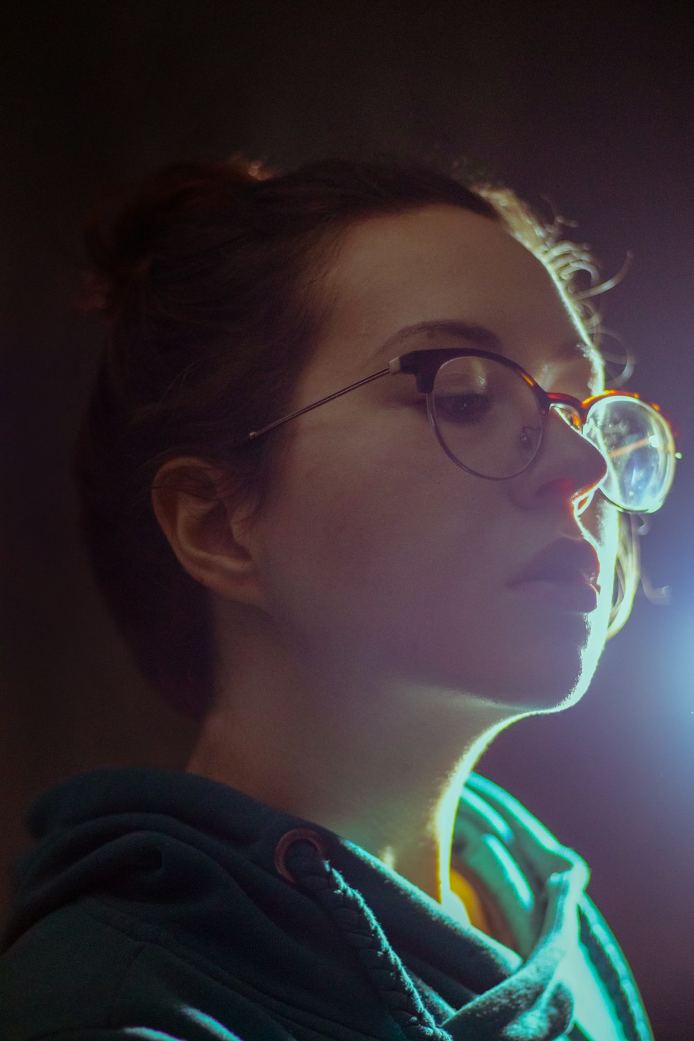 woman wearing teal draped shirt and eyeglasses