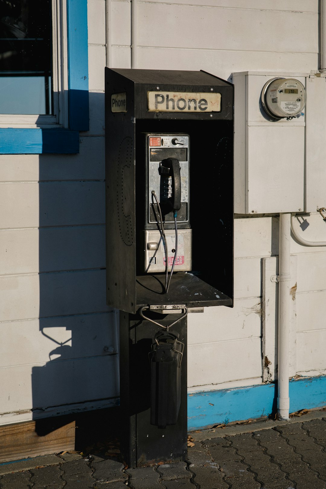 black coin telephone during daytime