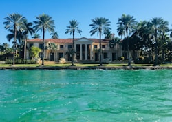 brown and white concrete house near body of water ahead