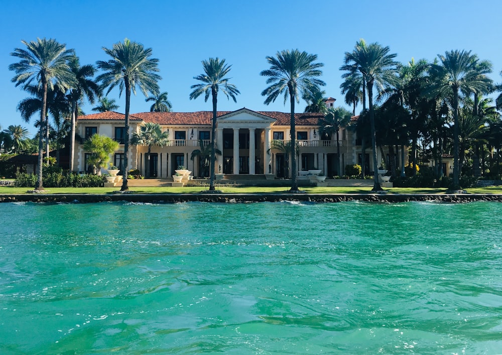 brown and white concrete house near body of water ahead