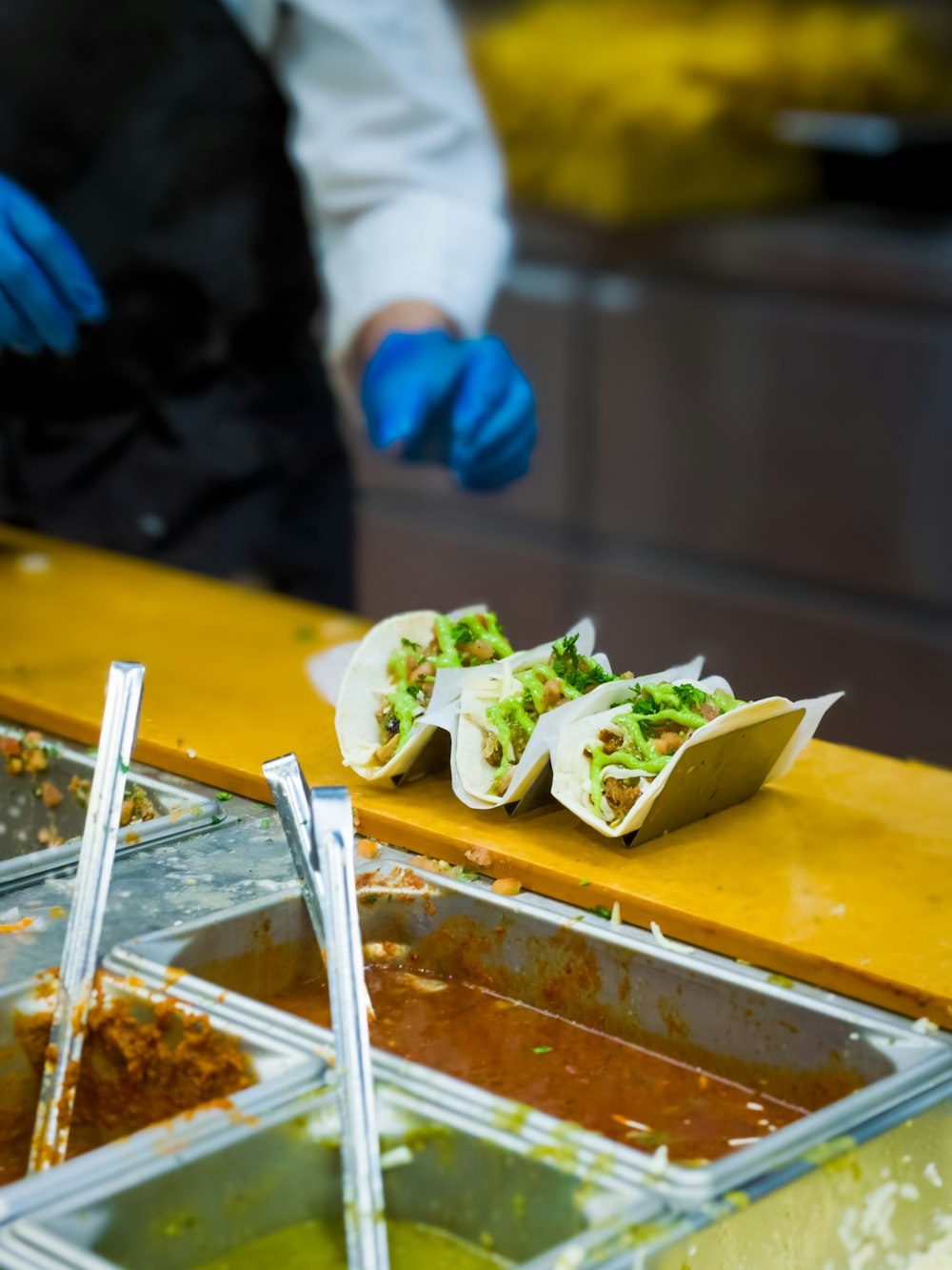 a person in blue gloves and gloves preparing food