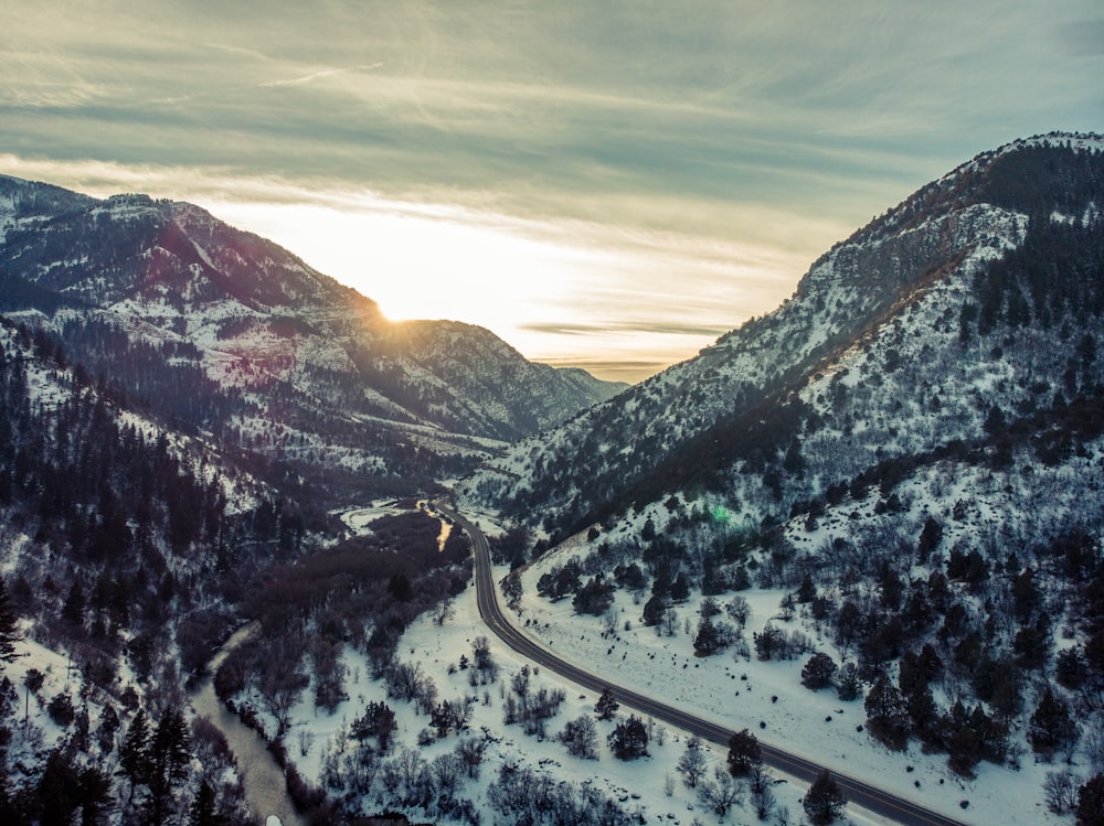 landscape photography of field and mountain covered with snow under white and blue sky