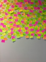 A wall filled with colorful post-it notes and sketches mapping out smileshere llc’s creative ideas.