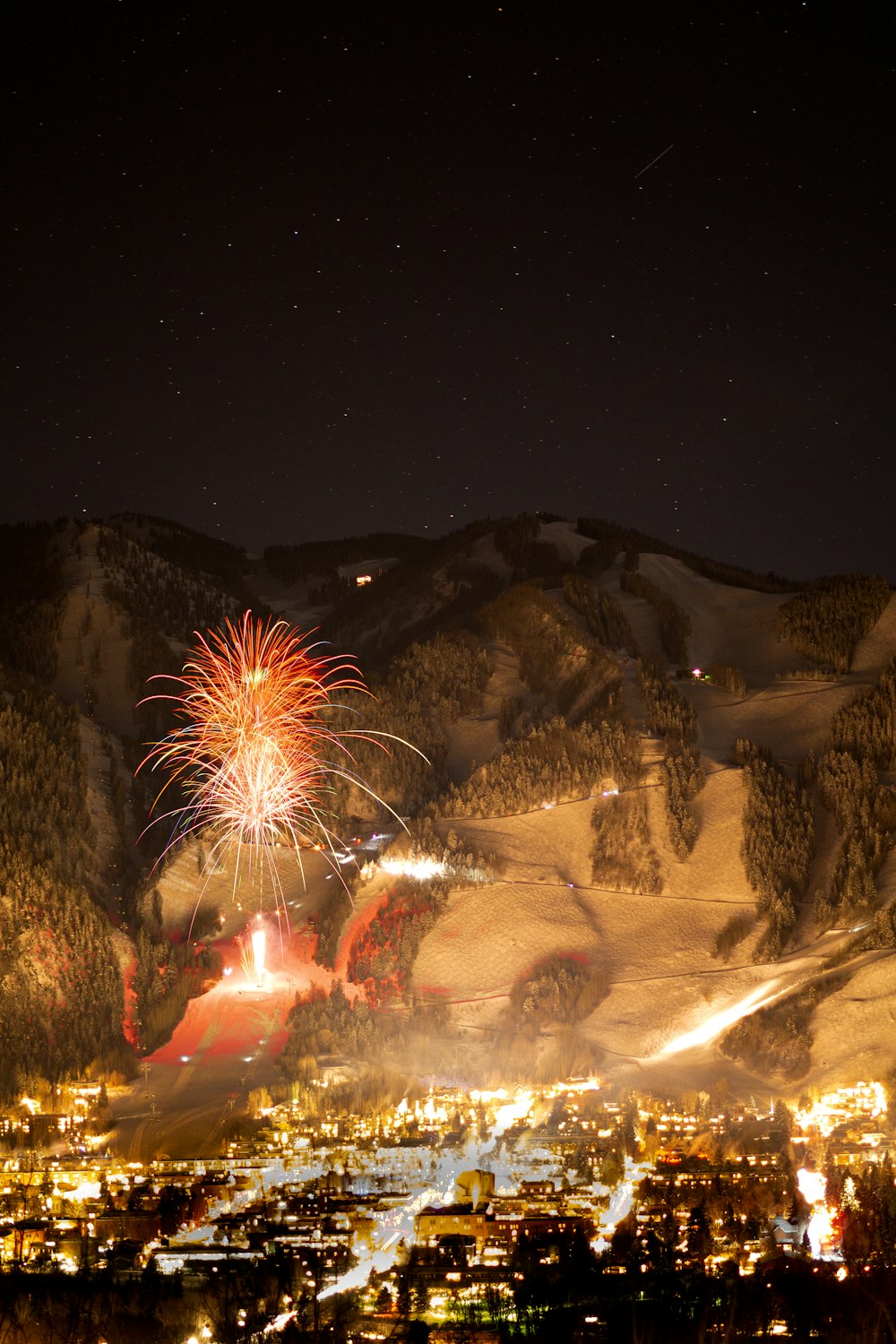 fireworks display above buildings viewing mountain