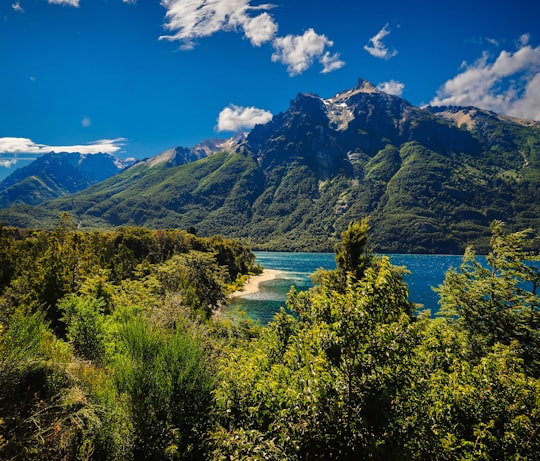 landscape photography of blue body of water viewing mountain under blue and white sky in El Bolsón Argentina