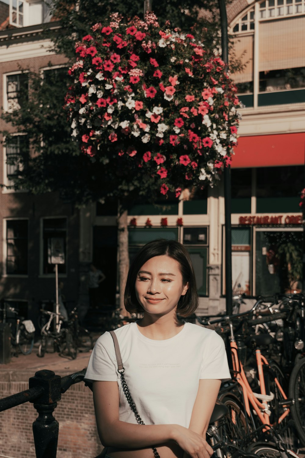 woman wearing white crew-neck shirt standing beside parked bikes