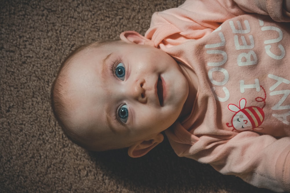 smiling child in long-sleeved top lying on brown canvas