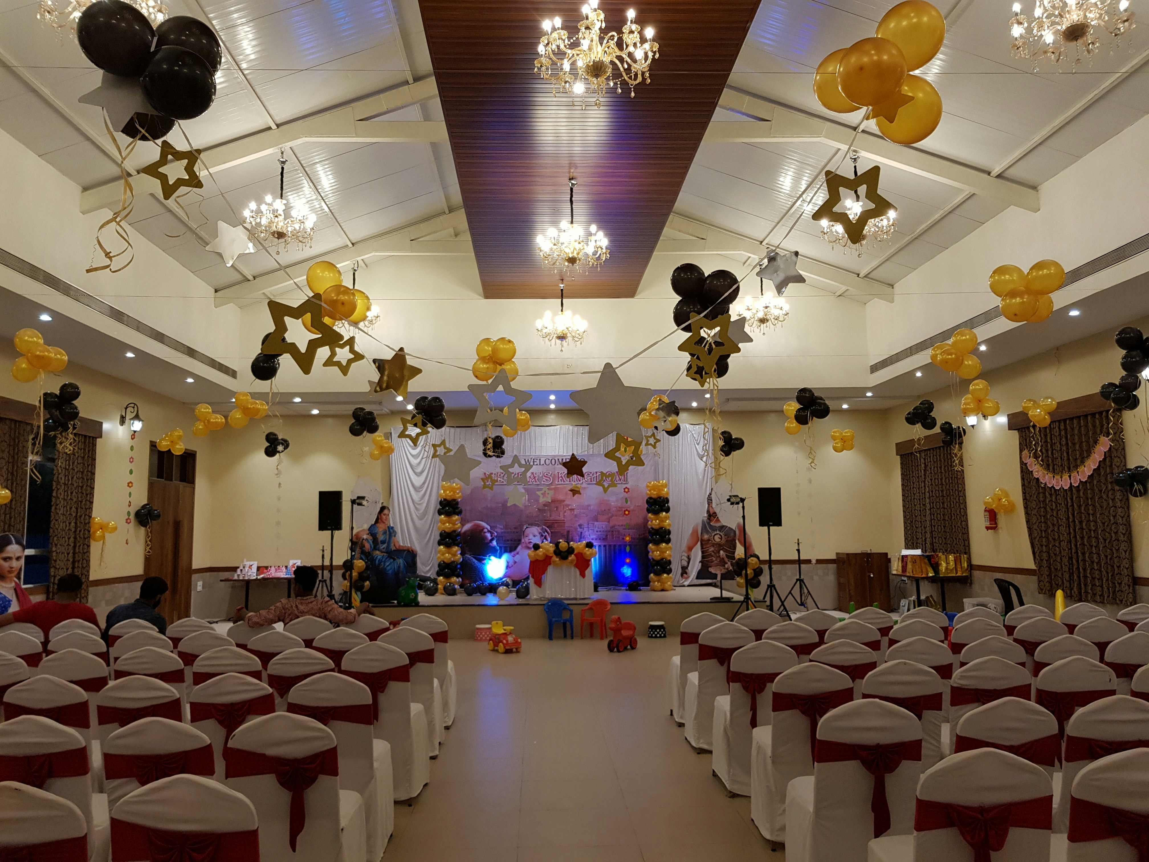 Colorful helium balloon arrangement in bright party room, white and gold decor
