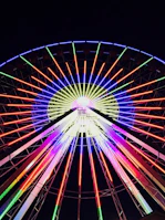 Close-up of a spinning wheel of fortune with bright neon lights.