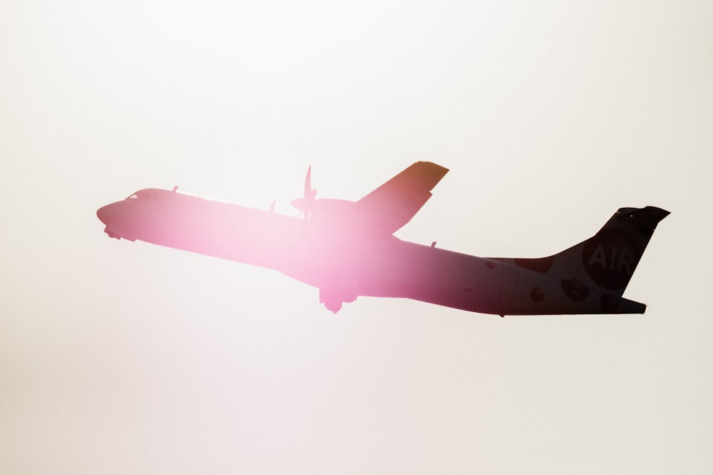 silhouette of airplane during golden hour