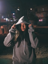 woman in hoodie while both hands holding the hood