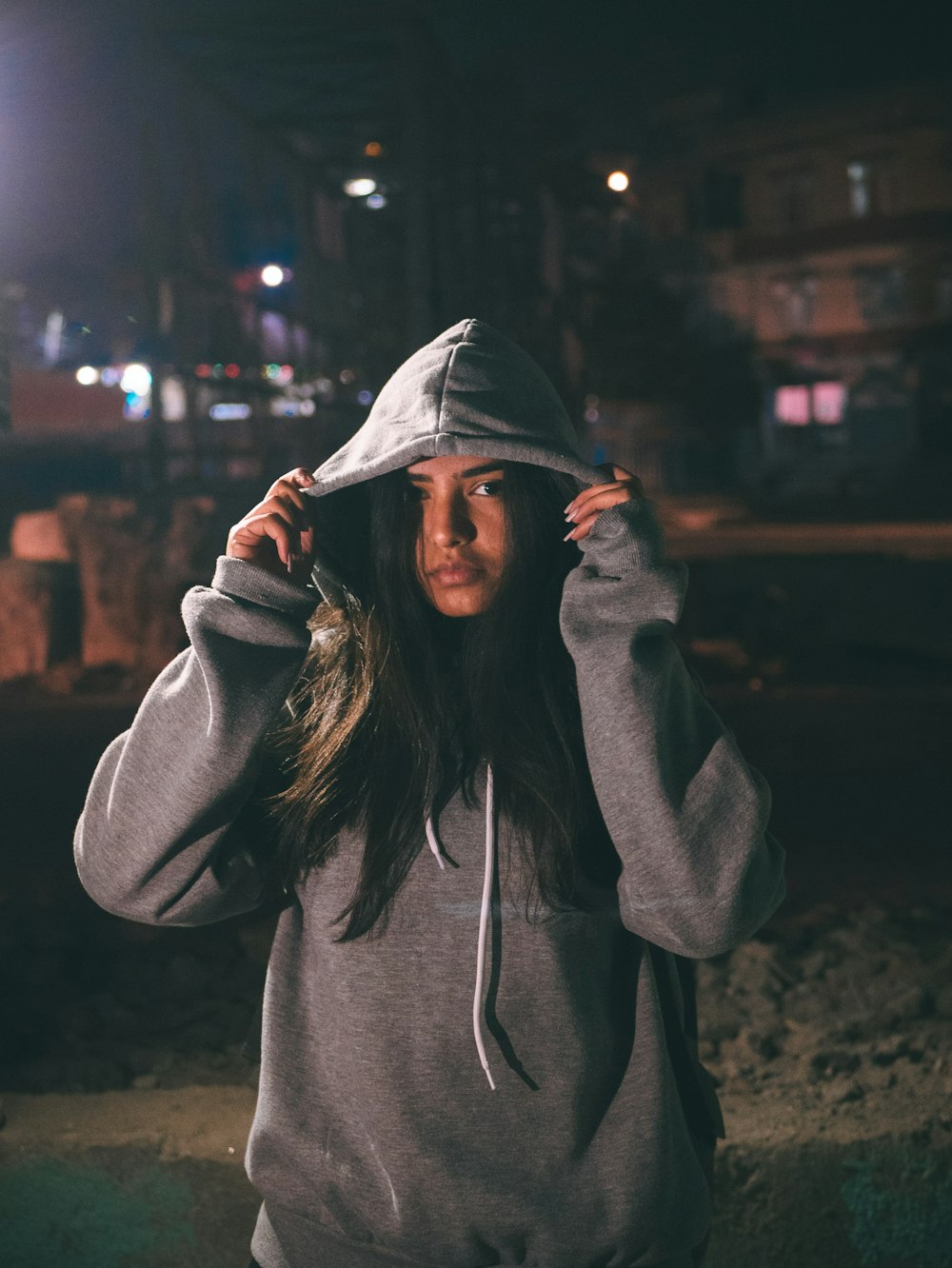 woman in hoodie while both hands holding the hood