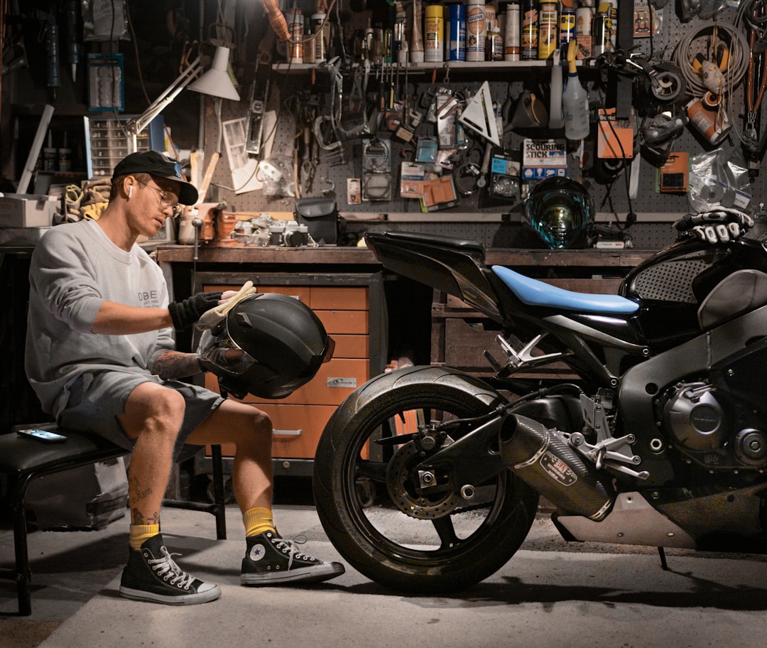 Motorcycle influencer cleaning helmet and custom motorcycle in LA garage - Photo by Garin Chadwick | best digital marketing - London, Bristol and Bath marketing agency