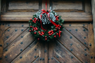 green and red wreath on brown wooden door