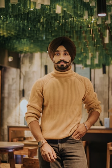 A warm portrait of Hakeem Noorpuri surrounded by fresh medicinal herbs in a cozy clinic.
