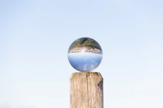 A serene crystal ball glowing softly on a wooden table.