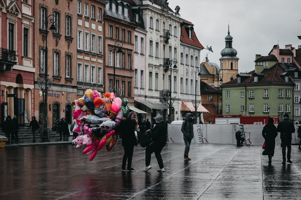 woman holding assorted-color balloons