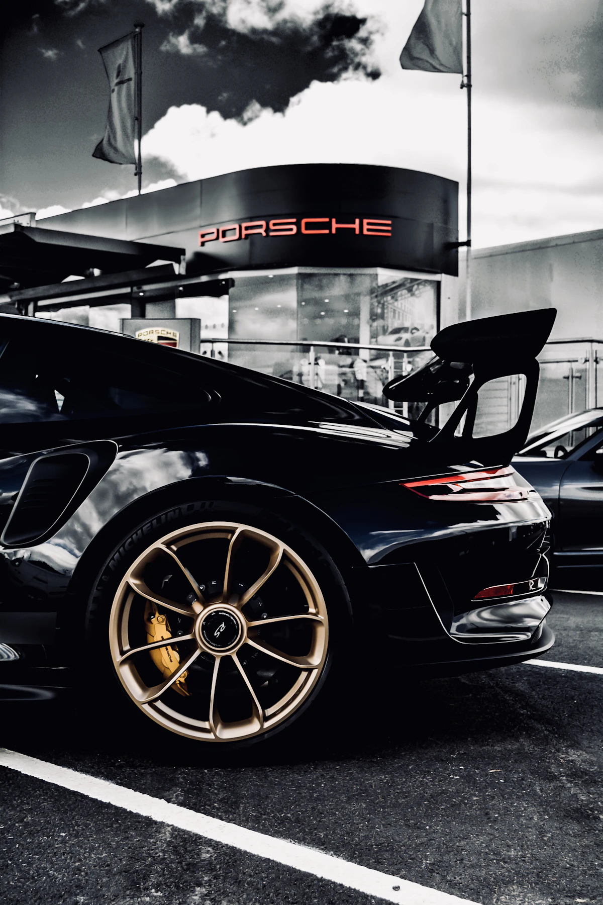 Moderner Porsche 911 mit Heckflügel in einer dunklen Halle