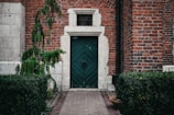 Elegant wooden door framed by lush greenery at a cozy house.