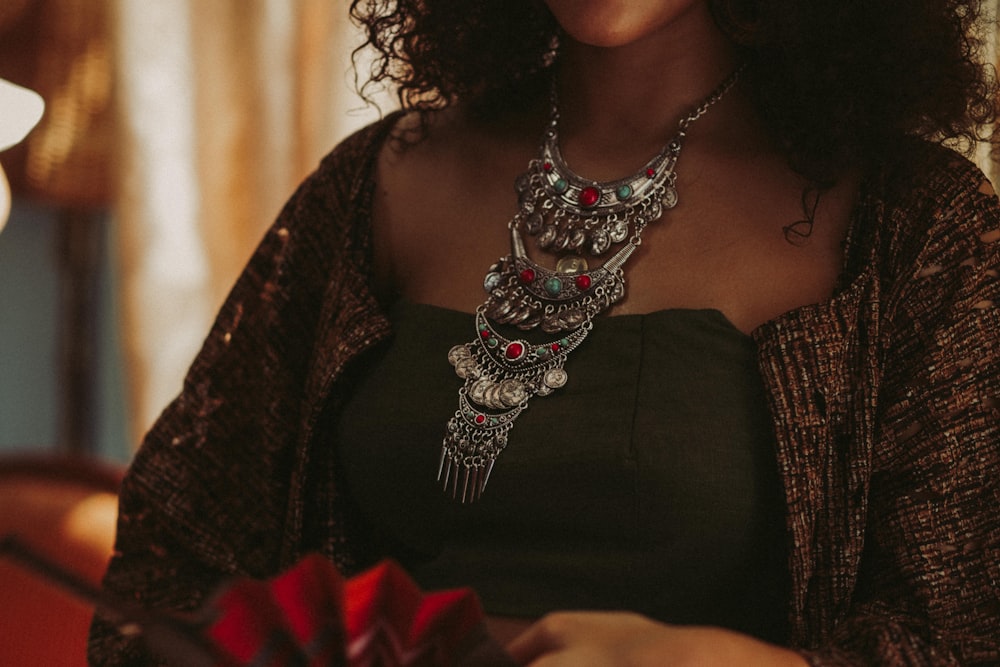 woman wearing silver-colored bib necklace