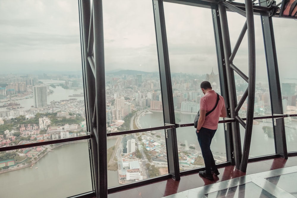 man standing beside glass window