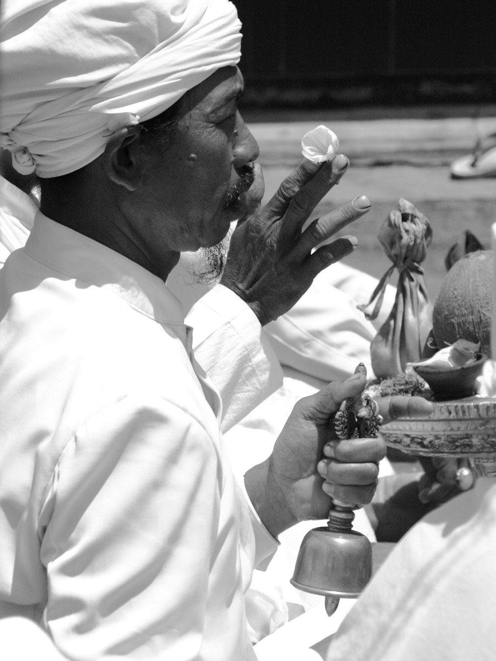 grayscale photography of man holding bell