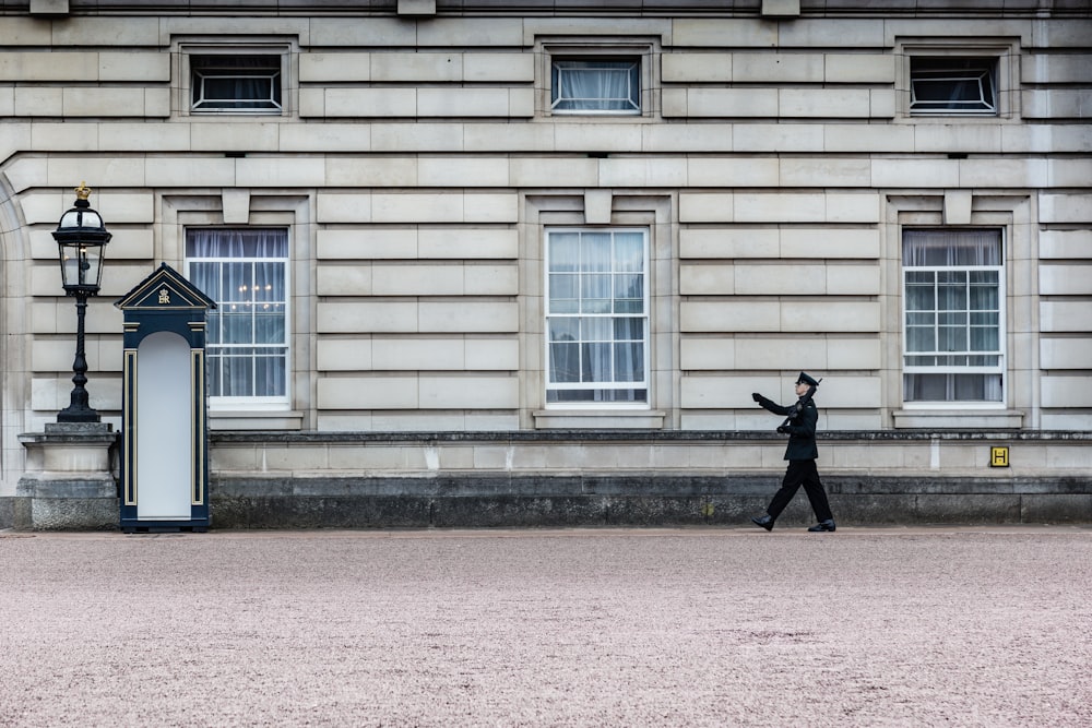 unknown person standing near gray house