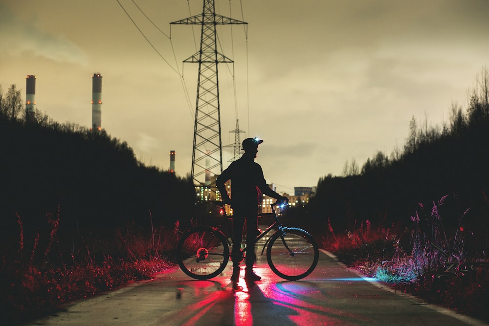silhouette of man holding bike