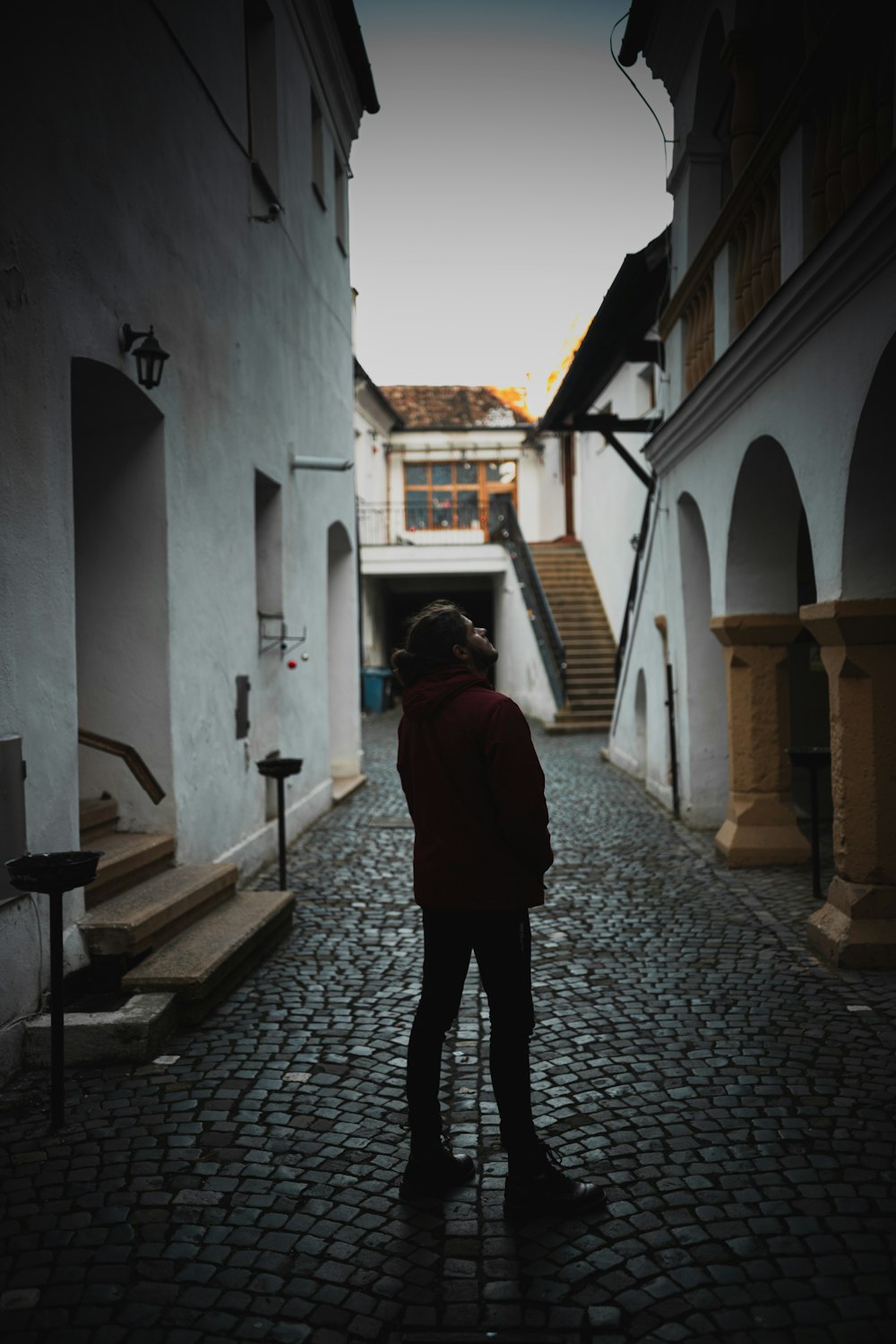 a person standing on a cobblestone street