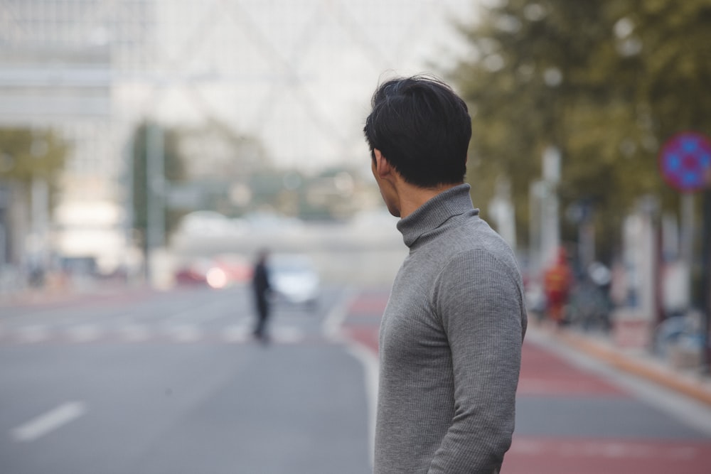 man gray turtleneck shirt standing road during daytime