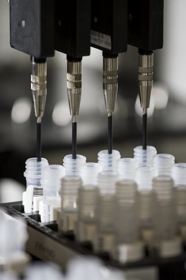 Row of precise digital pipettes neatly arranged against a soft blue background