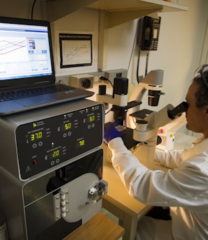 man looking at microscope