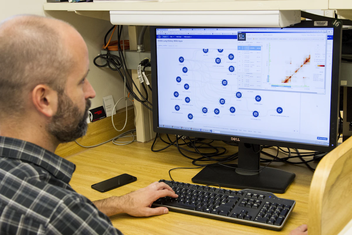 Clinical researcher reviewing genomic or molecular data on a workstation