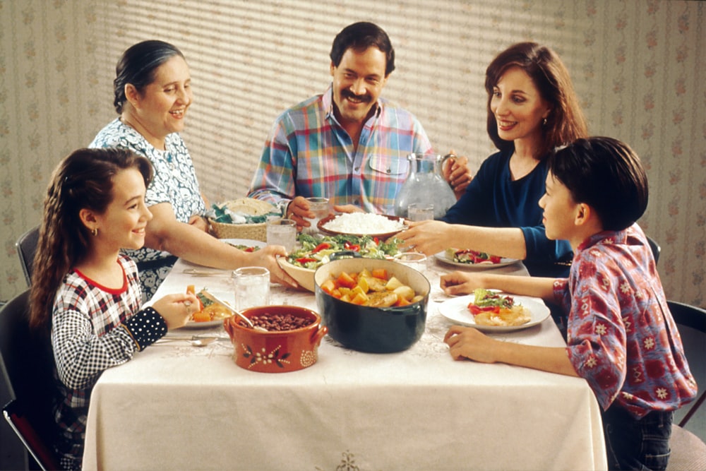 grupo de pessoas que comem dentro de casa