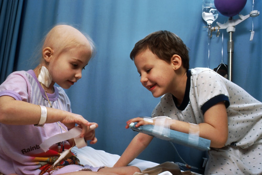 girl and boy playing on bed