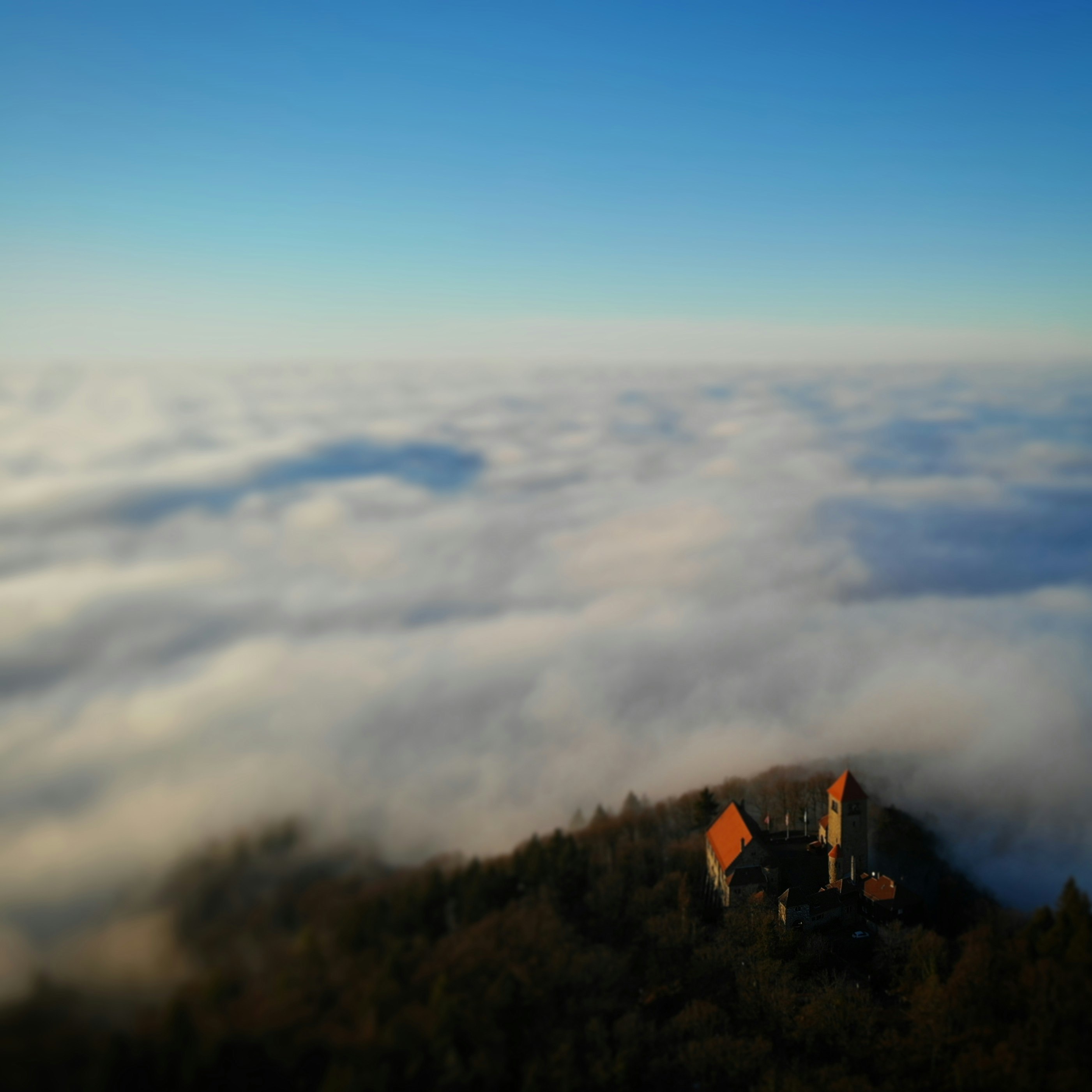 cabin on hill above clouds