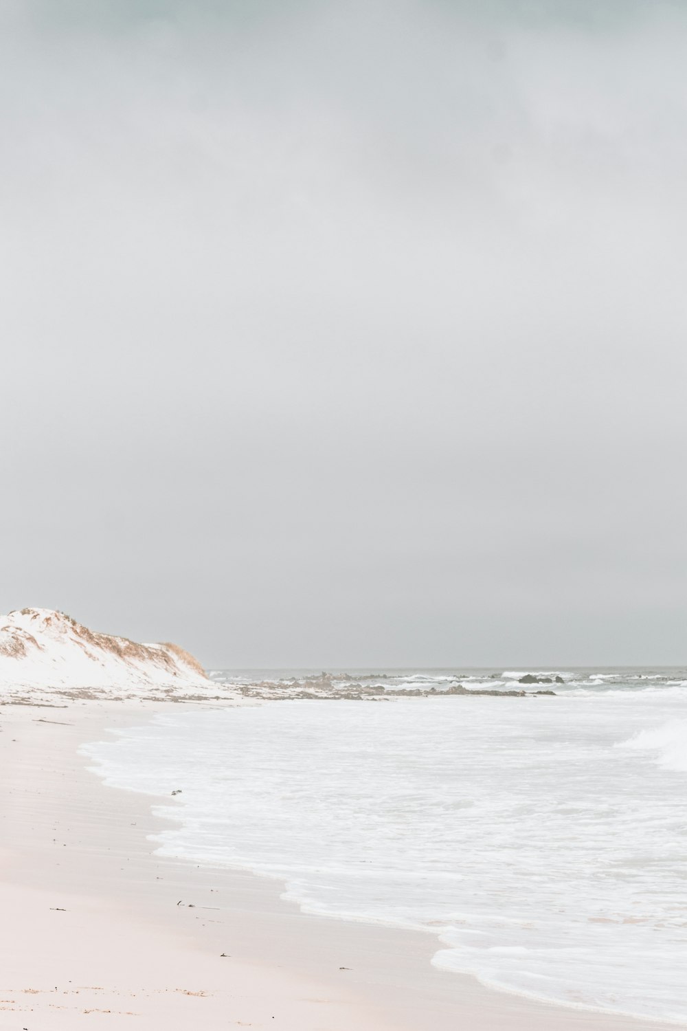 a person walking on a beach with a surfboard