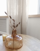 a table with a vase and candle on it