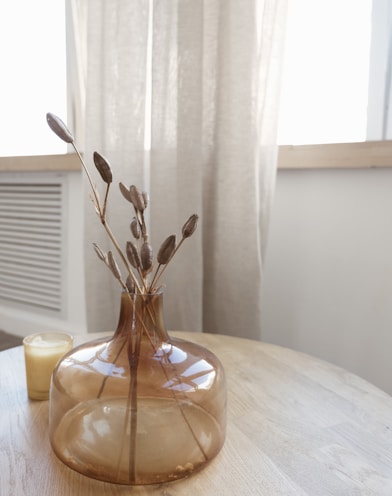 a table with a vase and candle on it