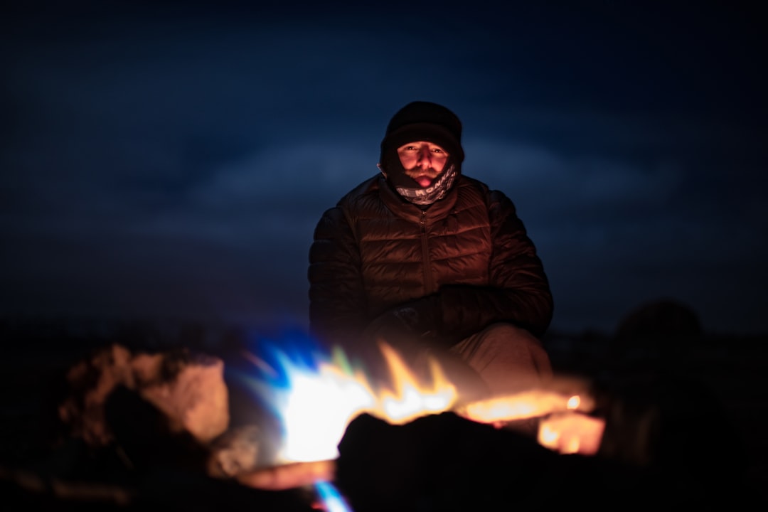 man sitting in front of campfire