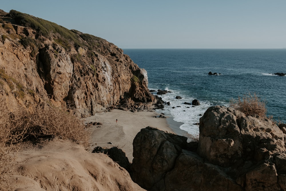 landscape photography of brown rock formation near body of water