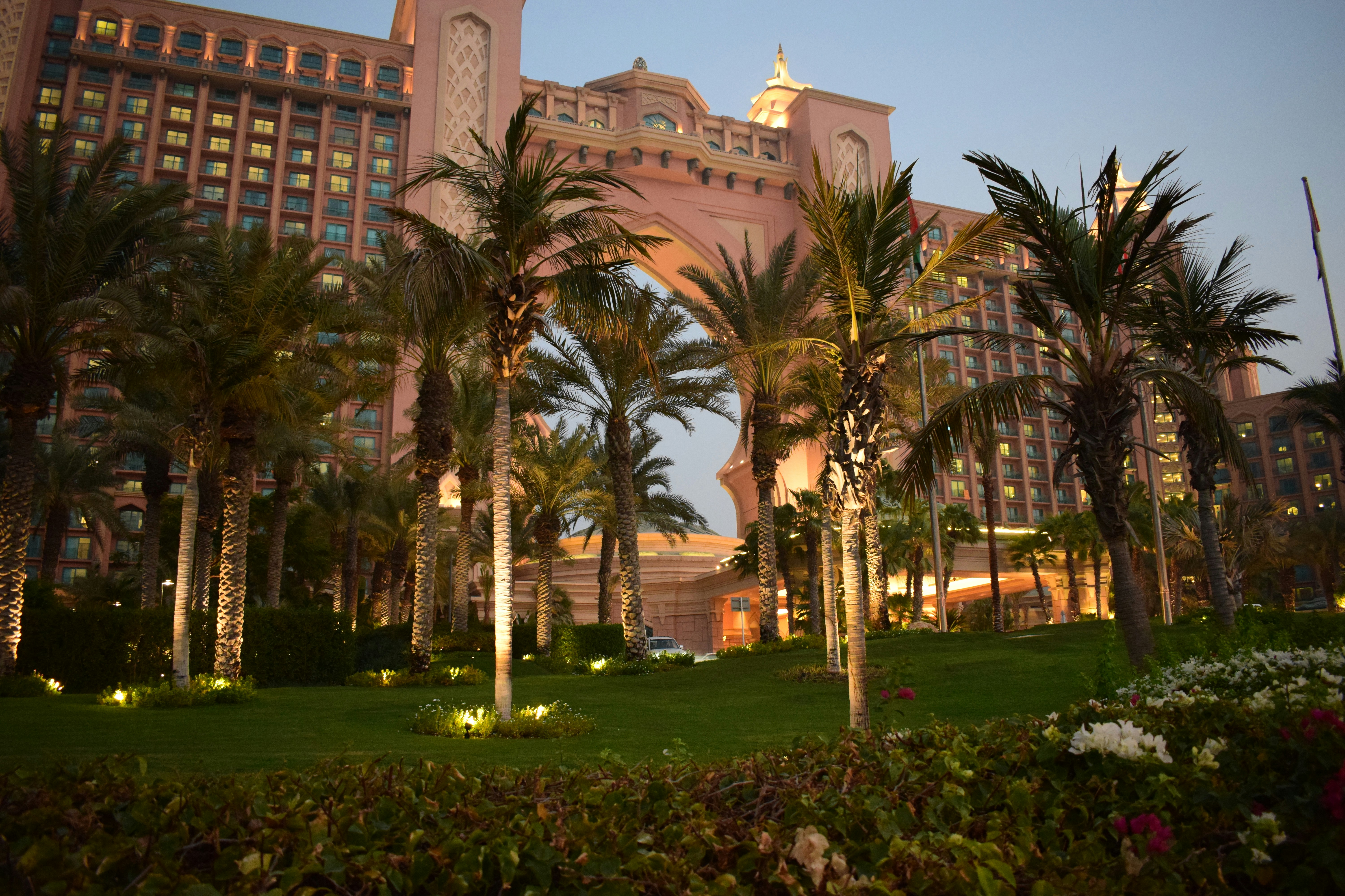 Resort garden with manicured lawns, colorful flowers, bright natural light, lush greenery