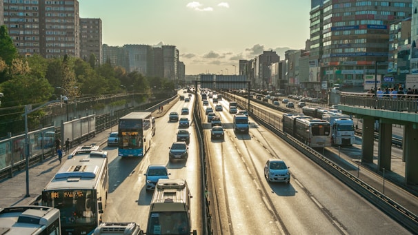 a highway filled with lots of traffic next to tall buildings