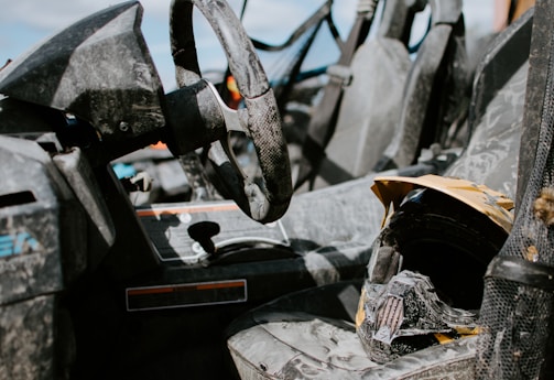 A worn combat helmet resting on a dusty military vehicle in a desert landscape.