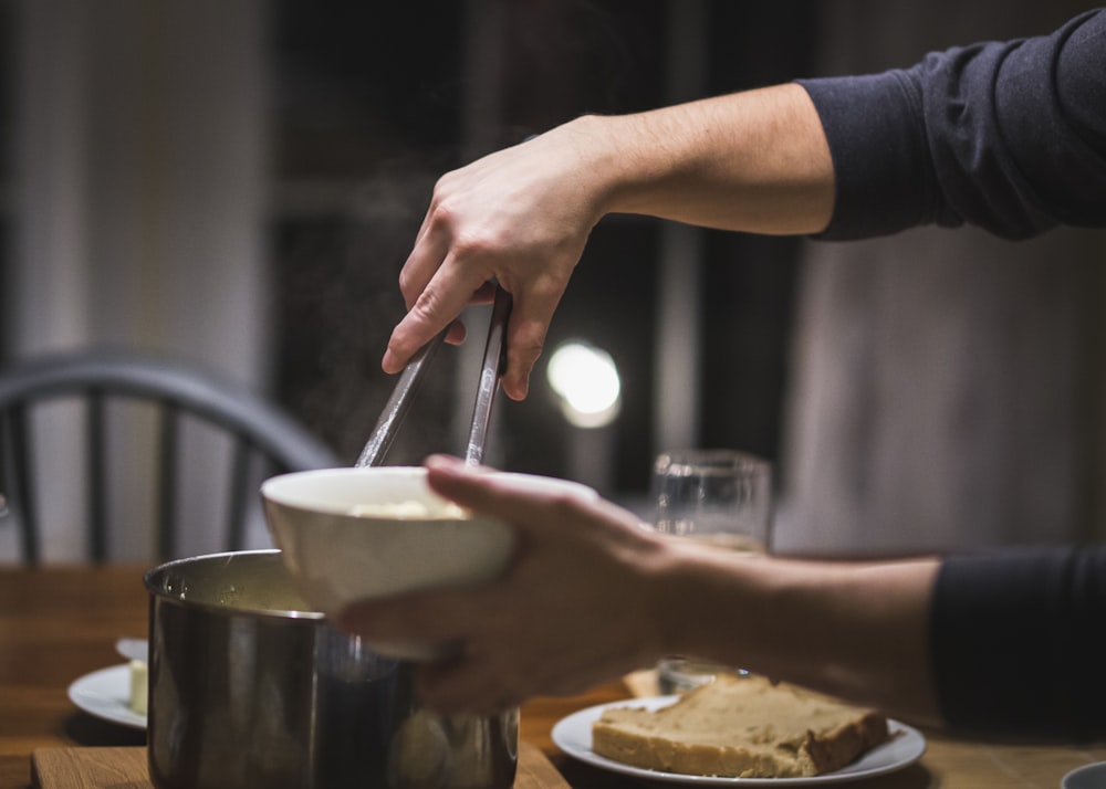 person holding white ceramic bowl