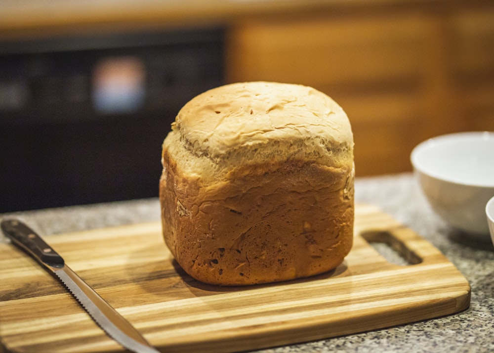 fotografia ravvicinata di pane su tagliere marrone