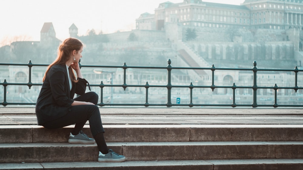 woman sitting on stairs at park during daytime