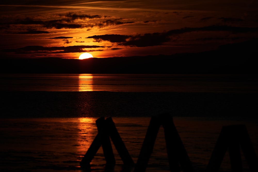 a sunset over a body of water with a boat in the distance