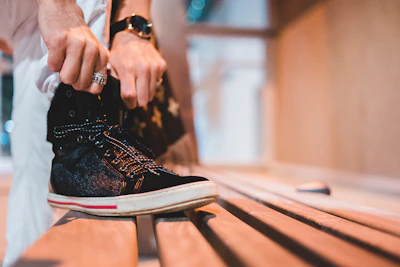 Woman sitting on a bench tying her comfortable, fashionable shoes.