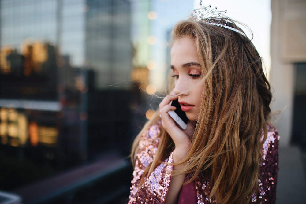 shallow focus photography of woman using smartphone outdoors